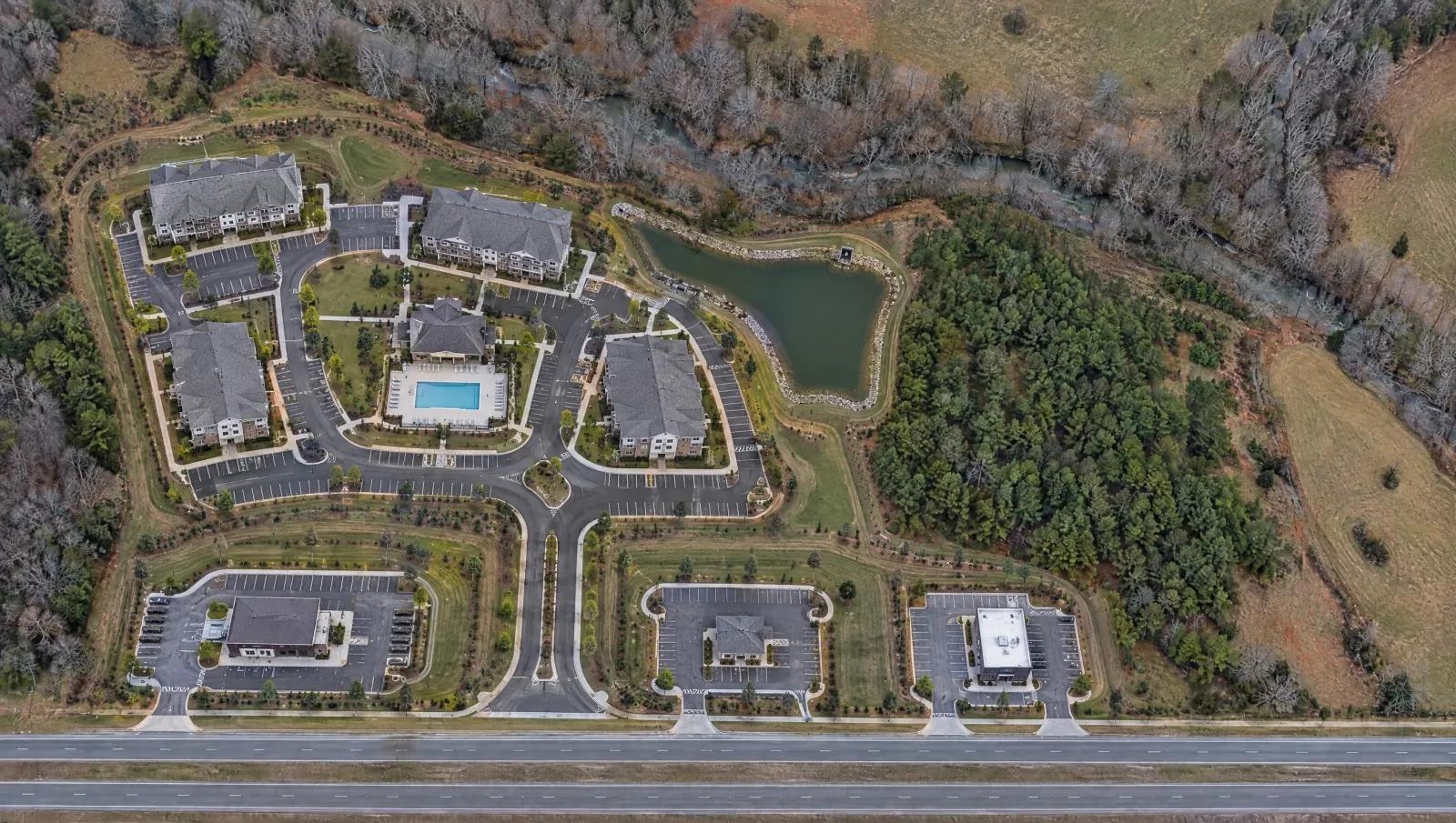 The same aerial after development: apartment buildings, ring road, pool, pond and outparcels